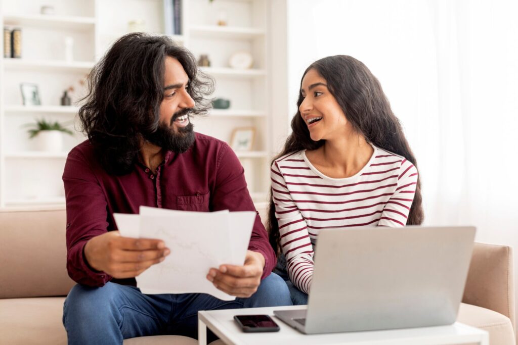 Cheerful,Young,Indian,Spouses,Paying,Bills,On,Internet,From,Home,